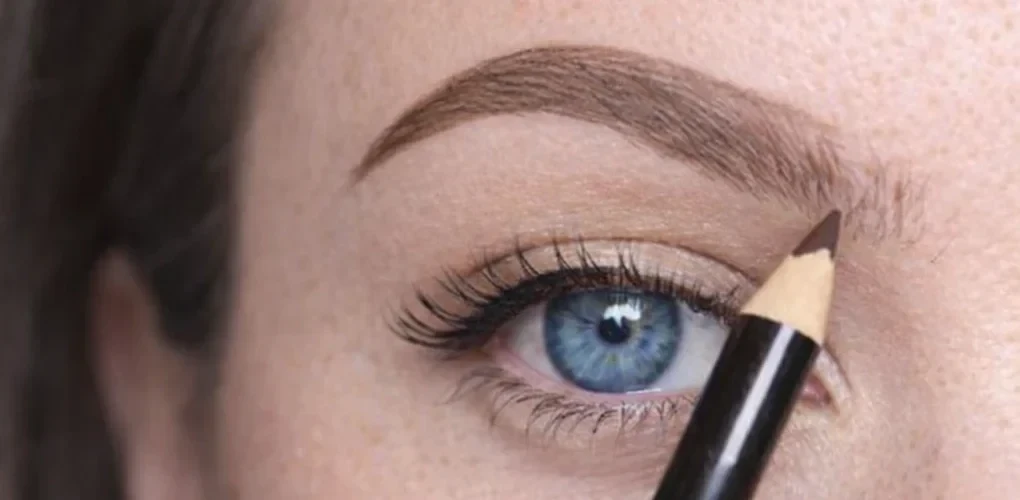 Estompage du maquillage des sourcils au pinceau biseauté pour un rendu fondu et naturel.