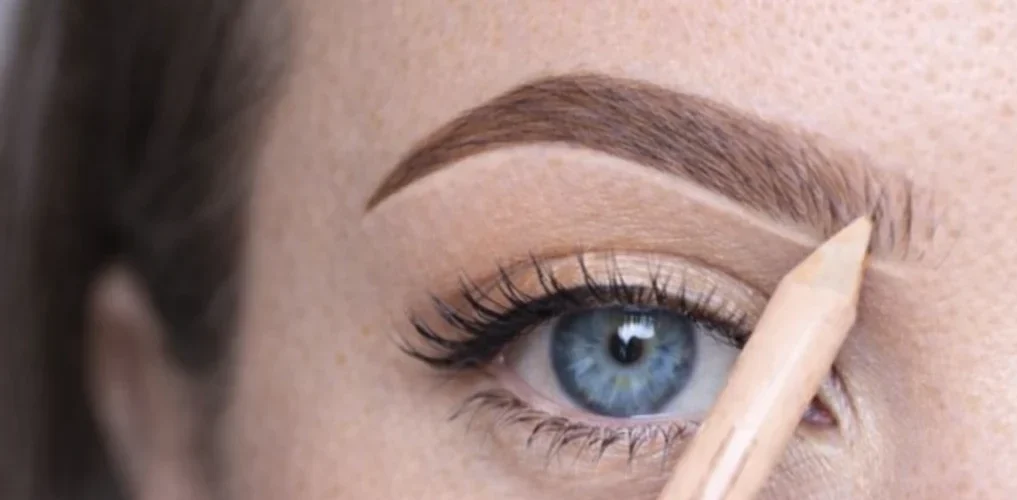 Estompage du maquillage des sourcils au pinceau biseauté pour un rendu fondu et naturel.