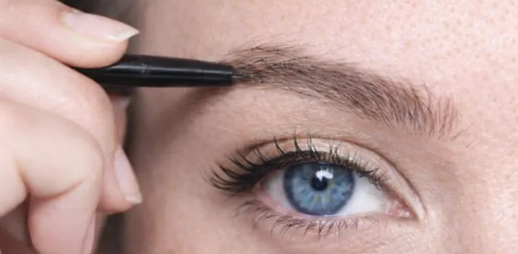 Estompage du maquillage des sourcils au pinceau biseauté pour un rendu fondu et naturel.